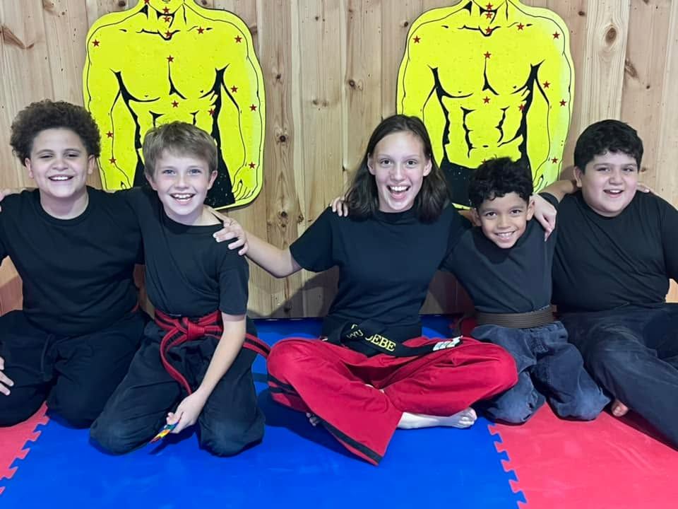 Kids martial arts class training together on the mat