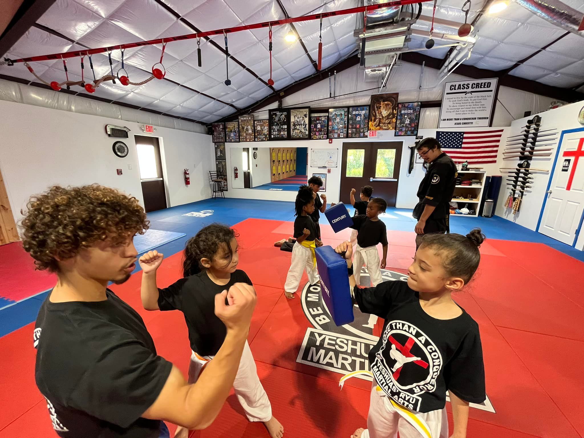 Instructor teaching a preschool student how to throw a kick